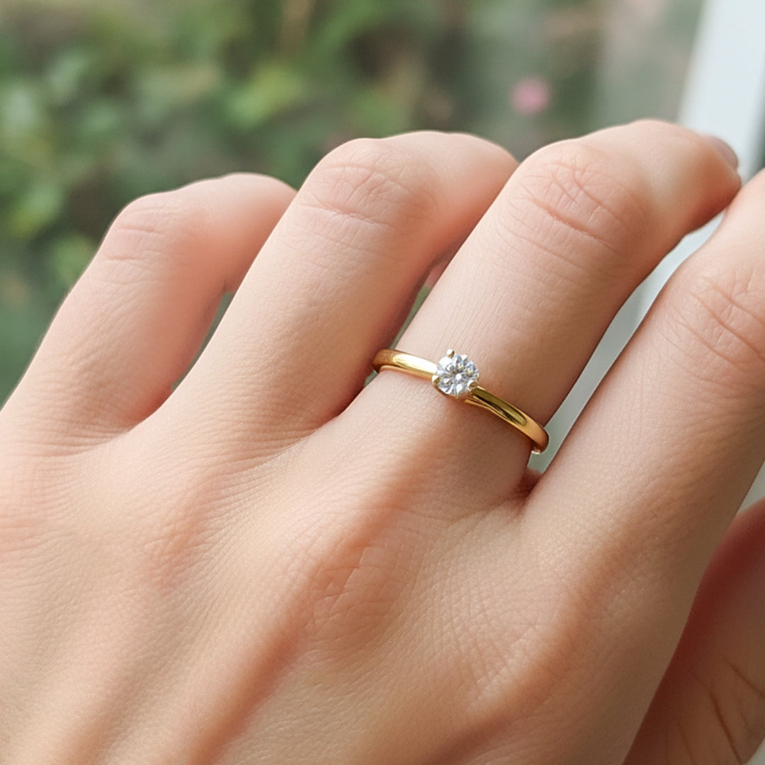 Mano de modelo usando un anillo solitario en oro amarillo de 18 quilates con cristales de Joyería Caracas. 