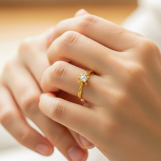 Mano de modelo usando un anillo en oro amarillo con forma de tulipán con cristal de Joyería Caracas. 