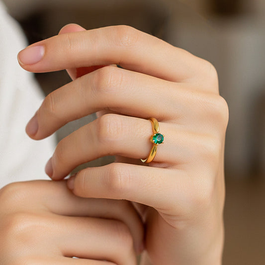 Mano de modelo usando un anillo inspirado en un tulipán oro amarillo de 18 quilates con cristal verde de Joyería Caracas. 