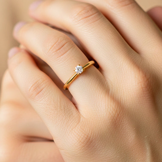 Mano de modelo usando un anillo solitario en oro amarillo de 18 quilates con cristal de Joyería Caracas. 