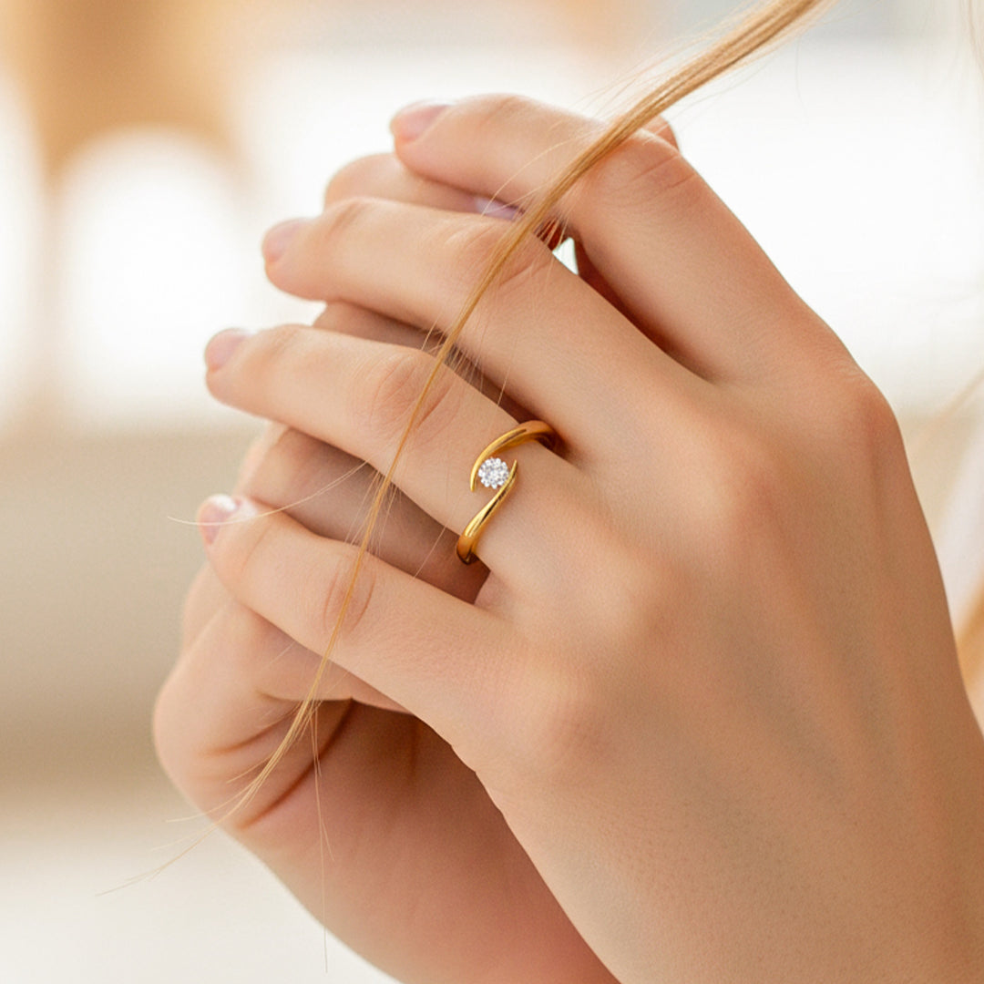 Mano de modelo usando un anillo en curva en oro amarillo de 18 quilates con cristal de Joyería Caracas. 