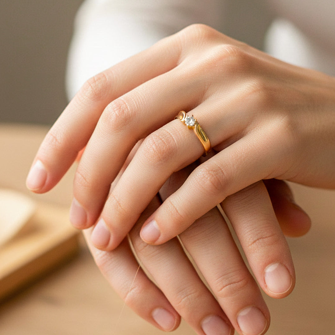 Mano de modelo usando un anillo de compromiso en oro amarillo de 18 quilates con cristal de Joyería Caracas. 