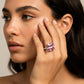 Modelo usando un anillo en oro blanco de 18 quilates con Zafiro (sintético) en tonalidades rosas y anaranjadas ubicado en el centro acompañado de Moissanitas de color blanco alrededor fabricado en Joyería Caracas. 