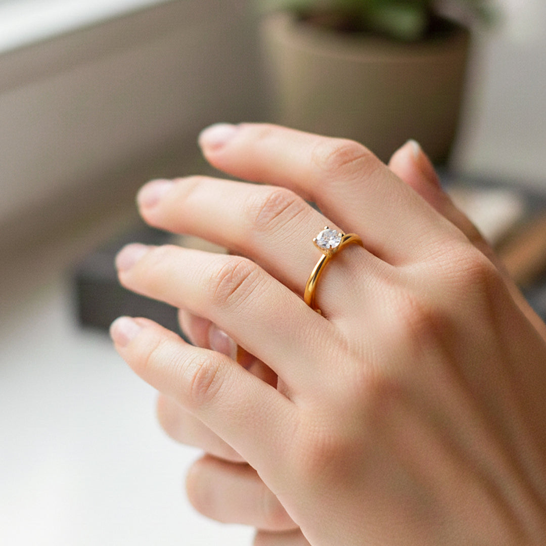 Mano de modelo usando un anillo solitario en oro amarillo de 18 quilates con cristal de Joyería Caracas. 
