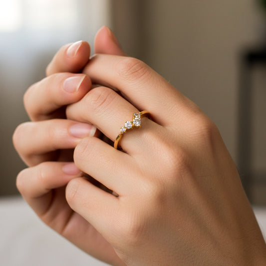 Mano de mujer usando un anillo en oro amarillo de 18 quilates con diseño en zig zag con cristales de color blanco de Joyería Caracas. 