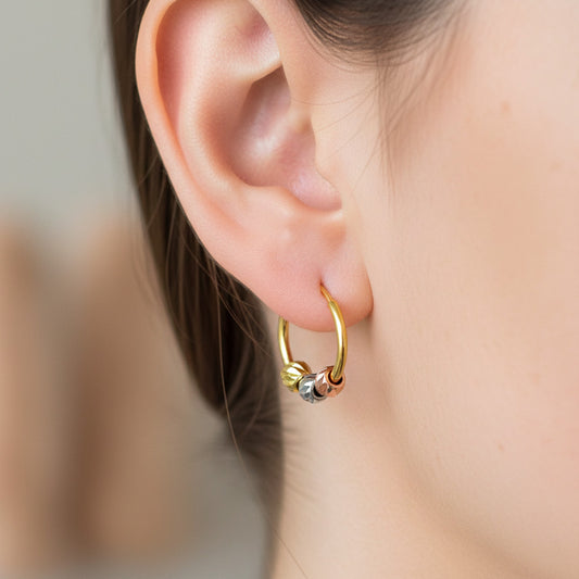 Oreja de modelo usando unos aretes sin fin con 3 esferas en 3 oros de 18 quilates de Joyería Caracas. 