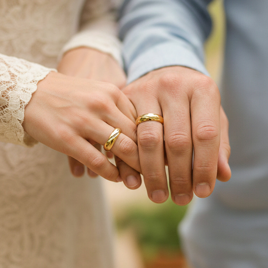 Mano de pareja en matrimonio usando unas argollas en oro amarillo de 18 quilates con cristales de Joyería Caracas. 