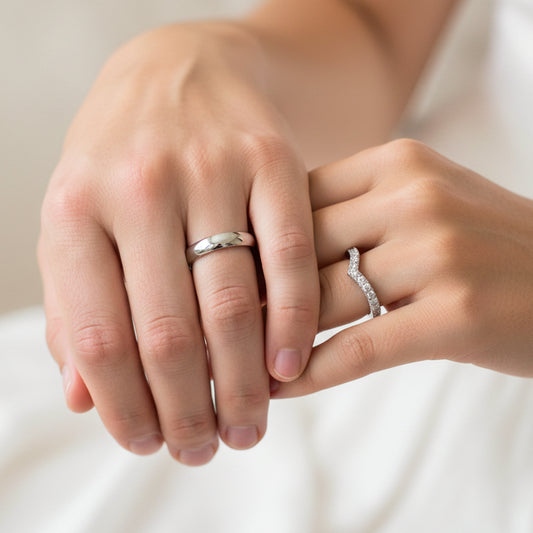 Mano de pareja usando unas argollas de matrimonio en oro blanco de 18 quilates con cristales de Joyería Caracas. 