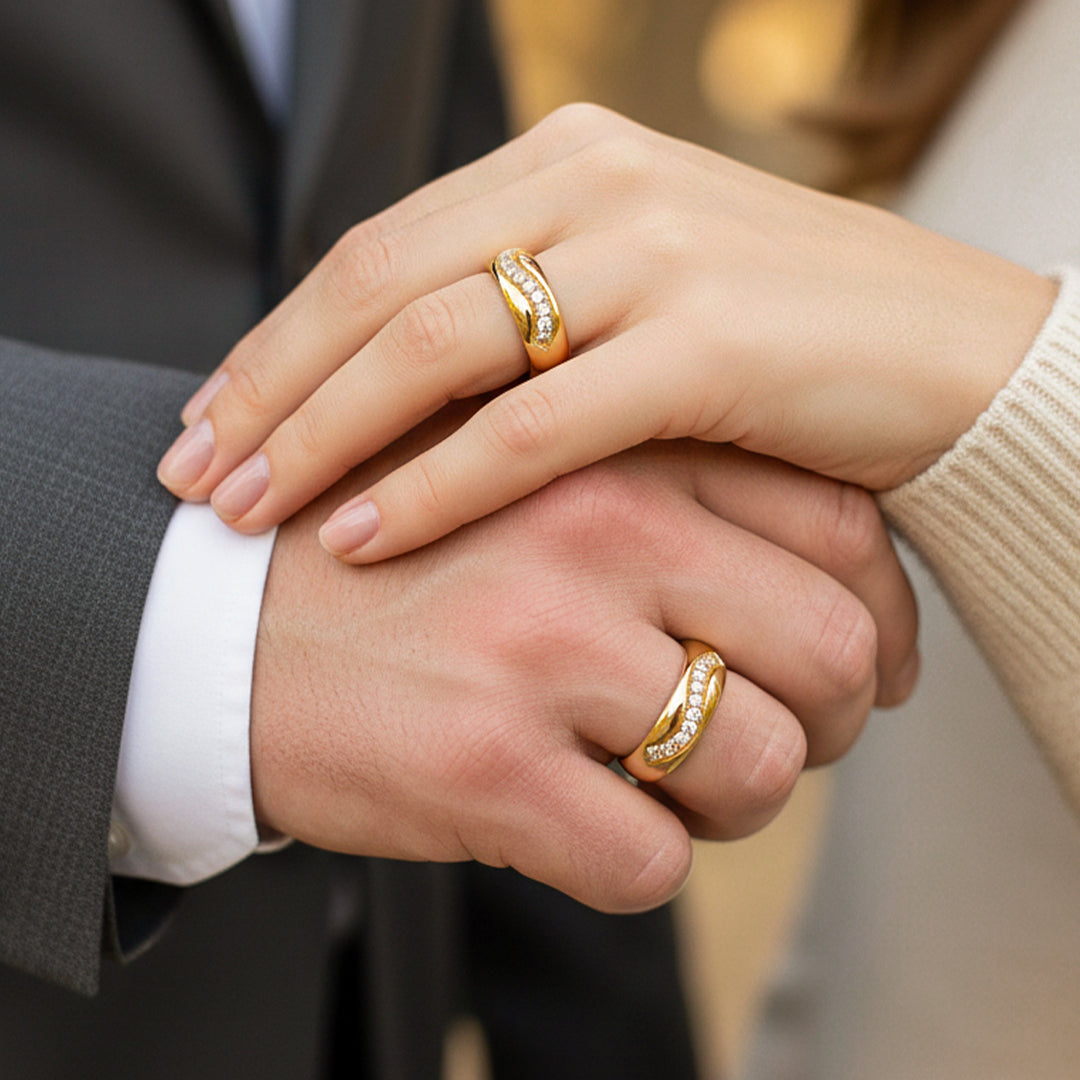 Manos de pareja en matrimonio usando unas argollas en oro amarillo de 18 quilates con cristales de Joyería Caracas. 