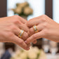 Manos de pareja usando unas argollas de matrimonio en oro amarillo y blanco de 18 quilates con cristales de Joyería Caracas. 