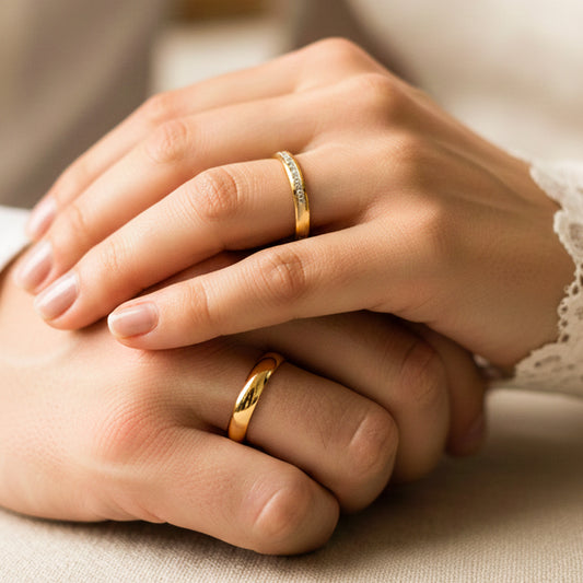 Manos de una pareja usando unas argollas de matrimonio en oro amarillo de 18 quilates con cristales de Joyería Caracas. 