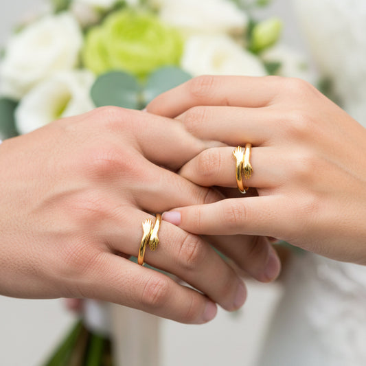 Mano de pareja en matrimonio usando unas argollas de matrimonio en oro amarillo de 18 quilates con forma de abrazo de Joyería Caracas. 