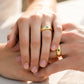 Mano de pareja en matrimonio usando unas argollas de matrimonio en oro amarillo de 18 quilates con cristales de Joyería Caracas. 