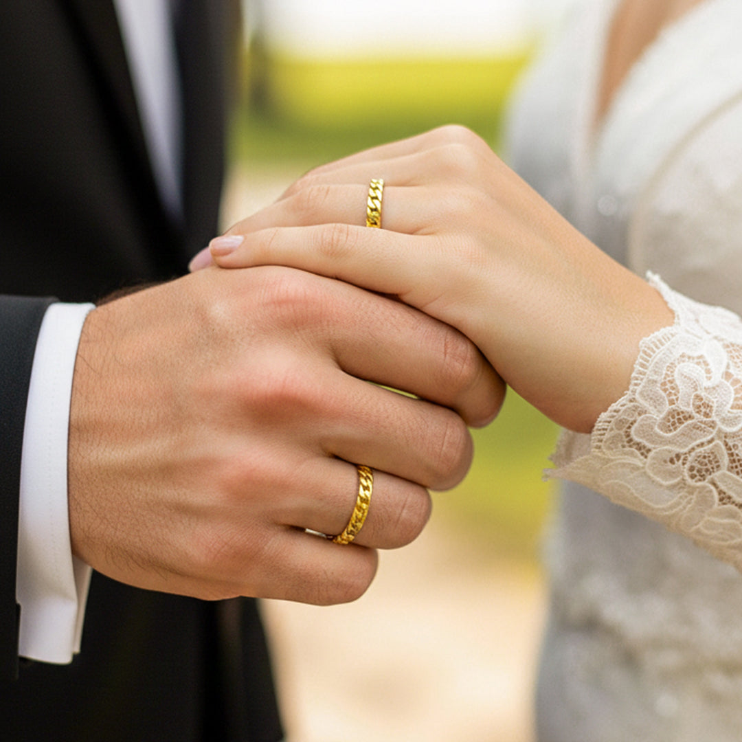 Manos de pareja en matrimonio usando unas argollas en oro amarillo de 18 quilates de Joyería Caracas. 