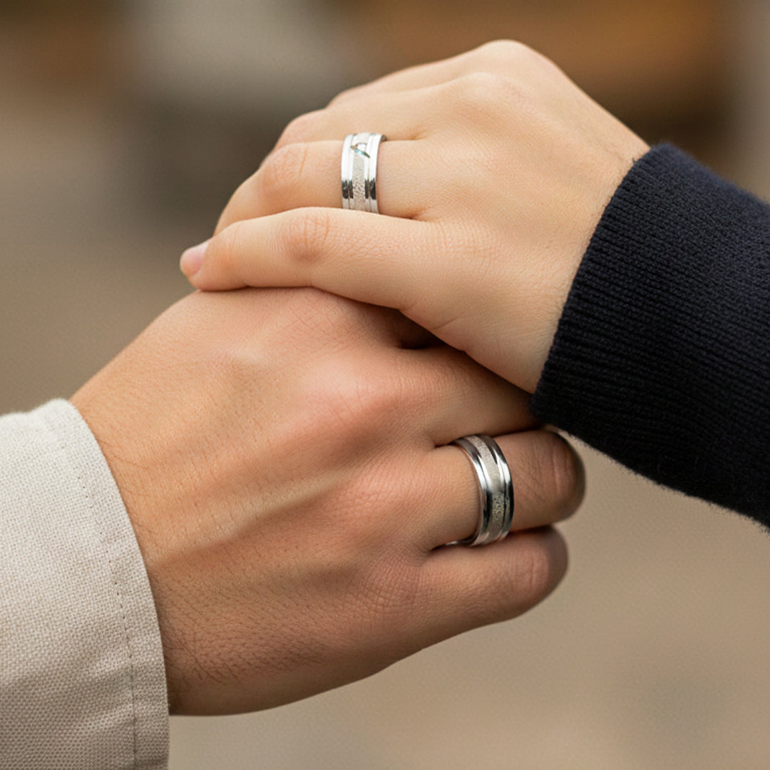 Mano de pareja en matrimonio usando unas argollas en oro blanco de 18 quilates con cristal de Joyería Caracas. 