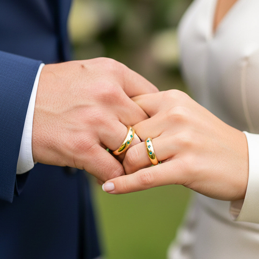 Manos de una pareja en matrimonio en oro amarillo de 18 quilates con Esmeraldas de Joyería Caracas. 