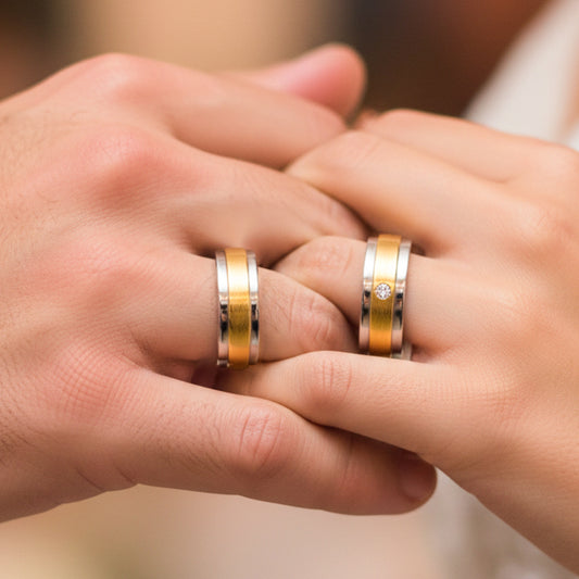 Mano de pareja usando unas argollas de matrimonio en oro blanco y amarillo de 18 quilates con cristal de Joyería Caracas. 
