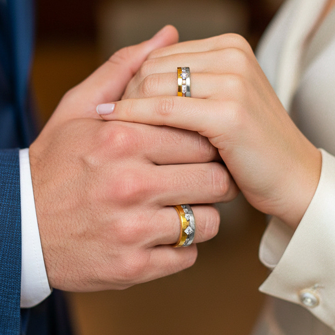 Mano de pareja en matrimonio usando unas argollas en oro amarillo y blanco de 18 quilates con Diamantes de Joyería Caracas.
