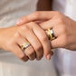Mano de pareja usando unas argollas de matrimonio en oro blanco y amarillo de 18 quilates con cristales de Joyería Caracas. 