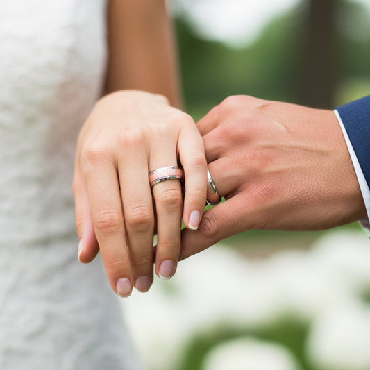 Mano de pareja en matrimonio usando unas argollas de matrimonio en oro blanco y rosa de 18 quilates de Joyería Caracas. 