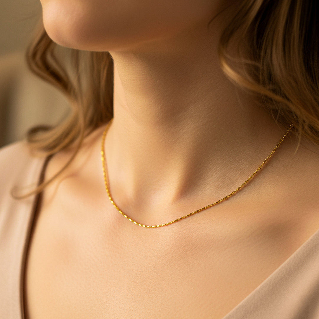 Cuello de mujer usando una cadena en tejido box & sphere en oro amarillo de 18 quilates de Joyería Caracas. 