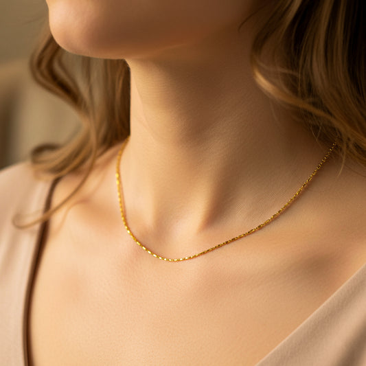 Cuello de mujer usando una cadena en tejido box & sphere en oro amarillo de 18 quilates de Joyería Caracas. 