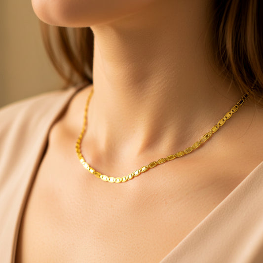 Cuello de mujer usando una cadena en tejido escalera espejo diamantada en oro amarillo de 18 quilates de Joyería Caracas. 