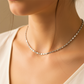 Cuello de mujer usando una cadena en tejido escalera plana en oro blanco de 18 quilates de Joyería Caracas. 