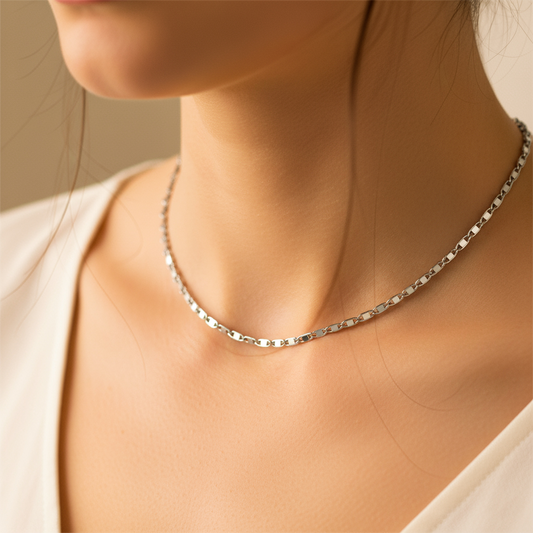 Cuello de mujer usando una cadena en tejido escalera plana en oro blanco de 18 quilates de Joyería Caracas. 