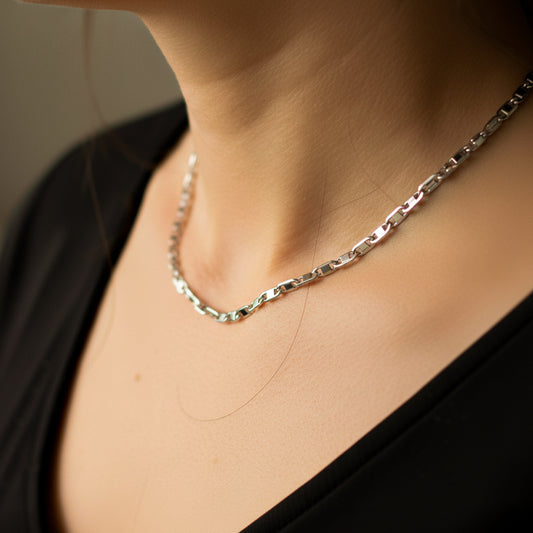 Cuello de mujer usando una cadena en tejido escalera plana en oro blanco de 18 quilates de Joyería Caracas. 