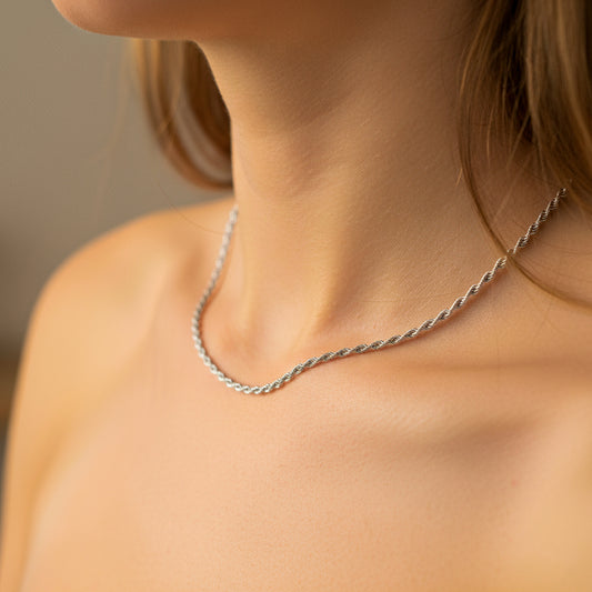 Cuello de mujer usando una cadena en tejido lazo en oro blanco de 18 quilates de Joyería Caracas. 