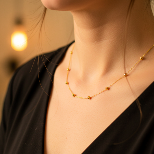 Cuello de mujer usando una cadena con esferas en oro amarillo de 18 quilates de Joyería Caracas. 