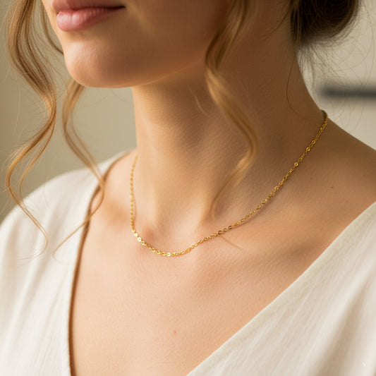 Cuello de mujer usando una cadena super skinny en oro amarillo de 18 quilates de Joyería Caracas. 