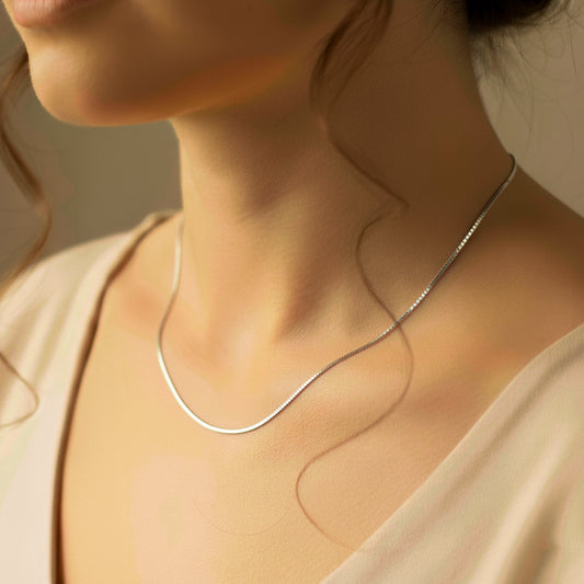 Cuello de mujer usando una cadena en tejido Venecia en oro blanco de 18 quilates de Joyería Caracas. 
