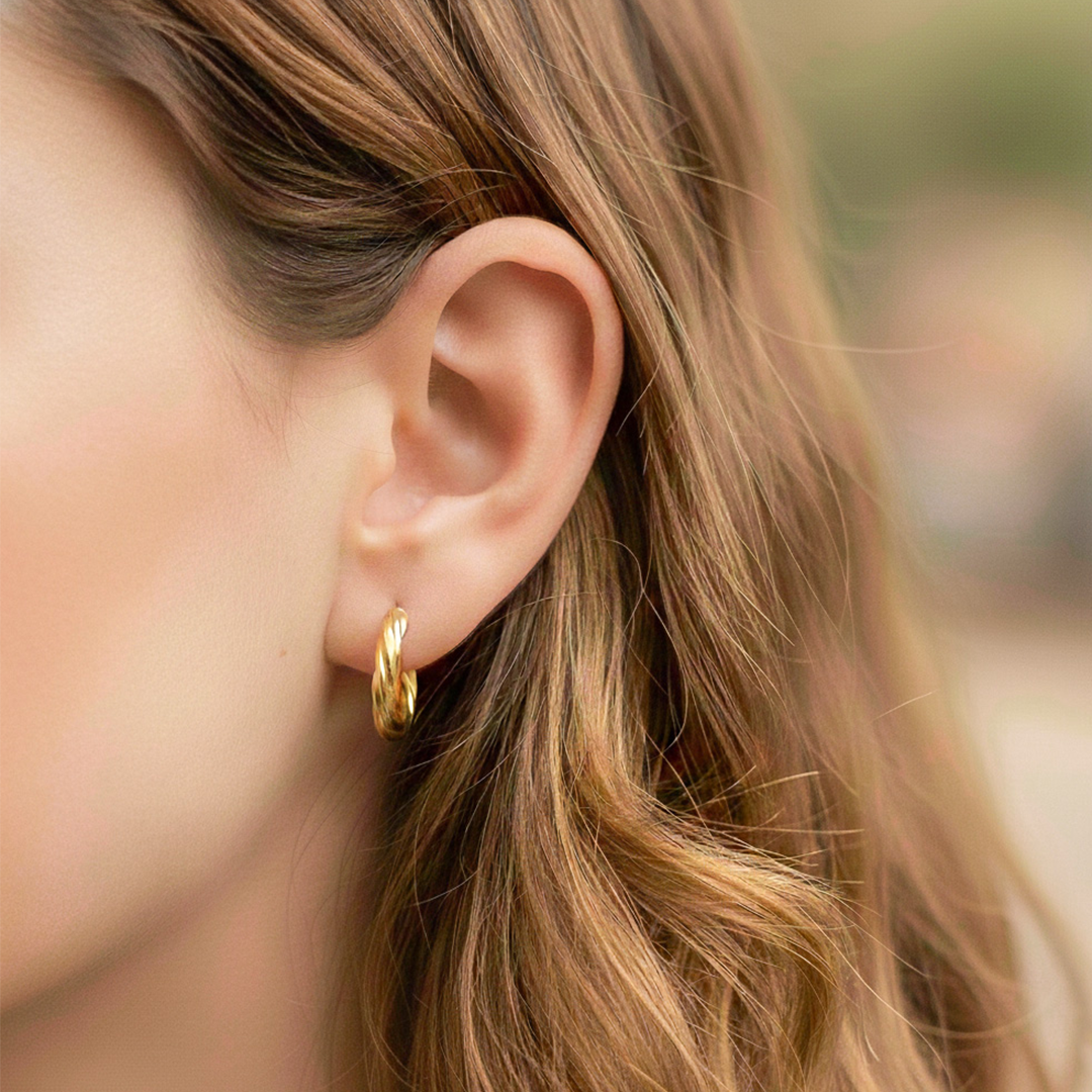 Oreja de modelo usando unas candongas melcocha clásicas en oro amarillo de 18 quilates de Joyería Caracas. 