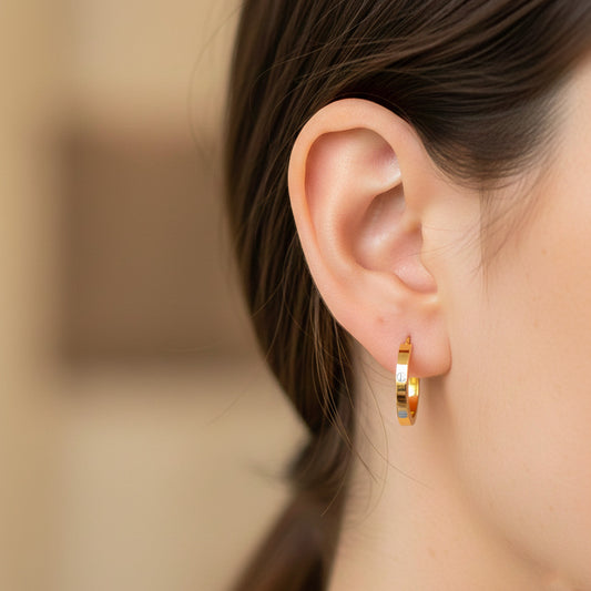 Oreja de modelo usando unas candongas en oro bicolor de 18 quilates de Joyería Caracas. 