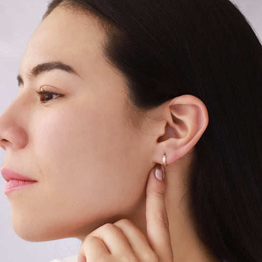 Oreja de mujer usando candongas diamantadas en oro amarillo de 18 quilates de Joyería Caracas.