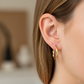 Oreja de modelo usando unas candongas entorchadas acanaladas en oro amarillo de 18 quilates de Joyería Caracas. 