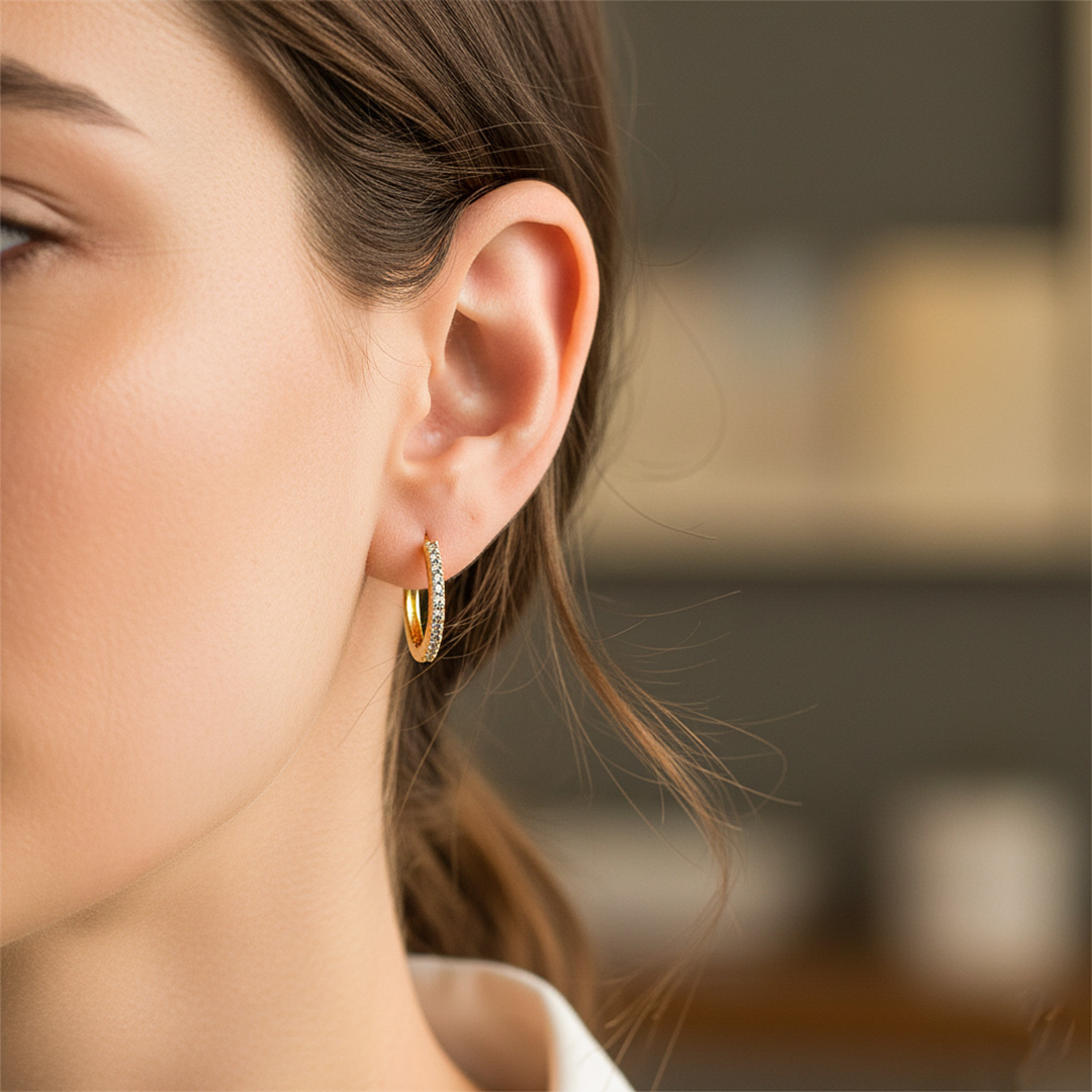 Oreja de modelo usando unas candongas en oro amarillo de 18 quilates con cristales de Joyería Caracas. 