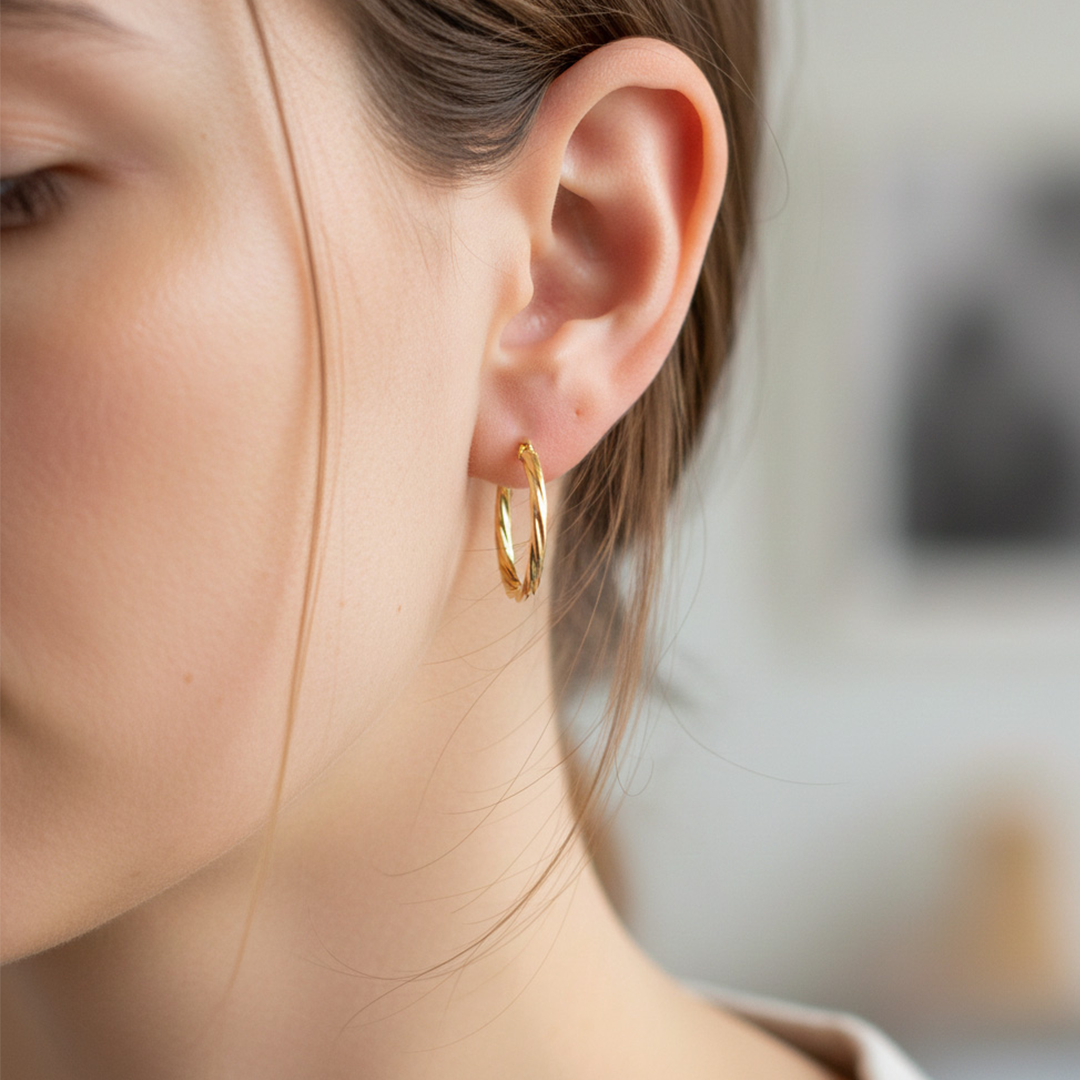 Oreja de modelo usando unas candongas melcocha en oro amarillo de 18 quilates de Joyería Caracas.