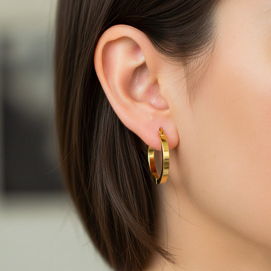 Oreja de modelo usando unas candongas en oro amarillo de 18 quilates de Joyería Caracas. 