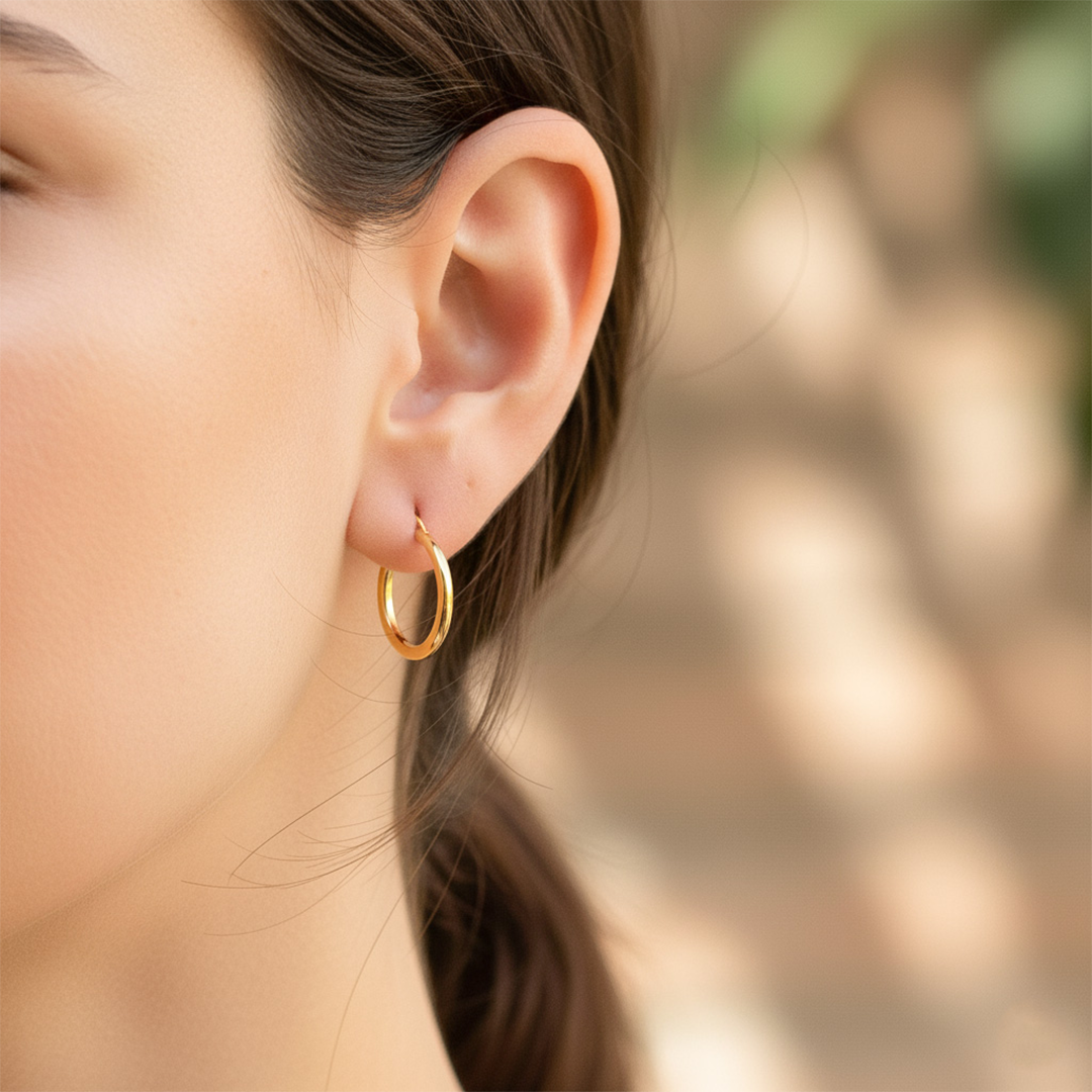 Oreja de modelo usando unas candongas tubo clásicas en oro amarillo de 18 quilates de Joyería Caracas. 