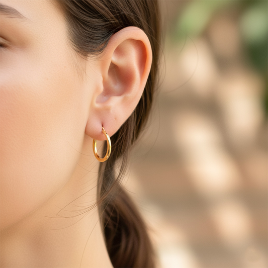 Oreja de modelo usando unas candongas tubo clásicas en oro amarillo de 18 quilates de Joyería Caracas. 