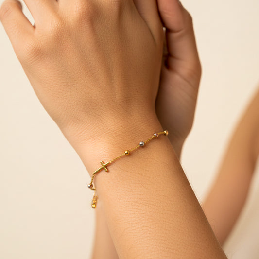 Mano de mujer usando una pulsera denario con esferas facetadas en oro amarillo, blanco y rosa de 18 quilates de Joyería Caracas. 