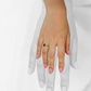 Mano de mujer con anillo en oro amarillo de 18 quilates con zafiro de color azul y 20 diamantes de color blanco, hecho en Joyería Caracas. 
