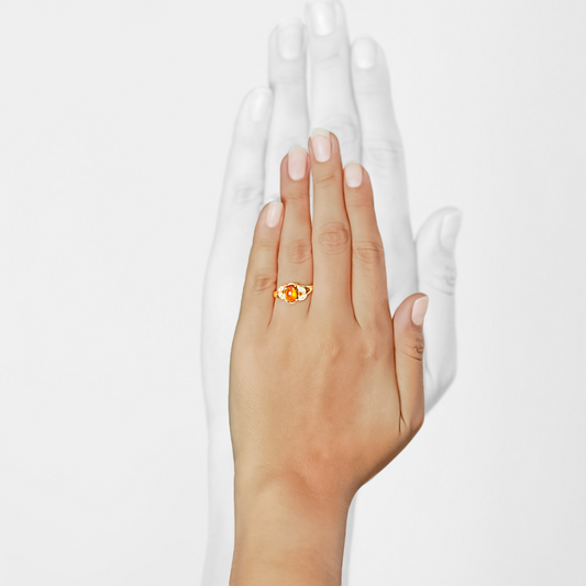Mano de mujer con anillo en oro amarillo de 18 quilates con piedra cabuchón de citrino y 8 diamantes de color blanco, hecho en Joyería Caracas. 