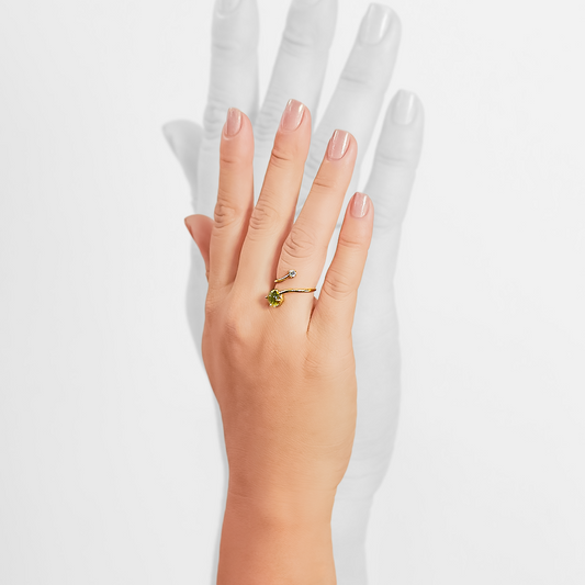 Mano de mujer con anillo en oro amarillo de 18 quilates con topacio en color verde y diamante de color blanco, hecho en Joyería Caracas. 