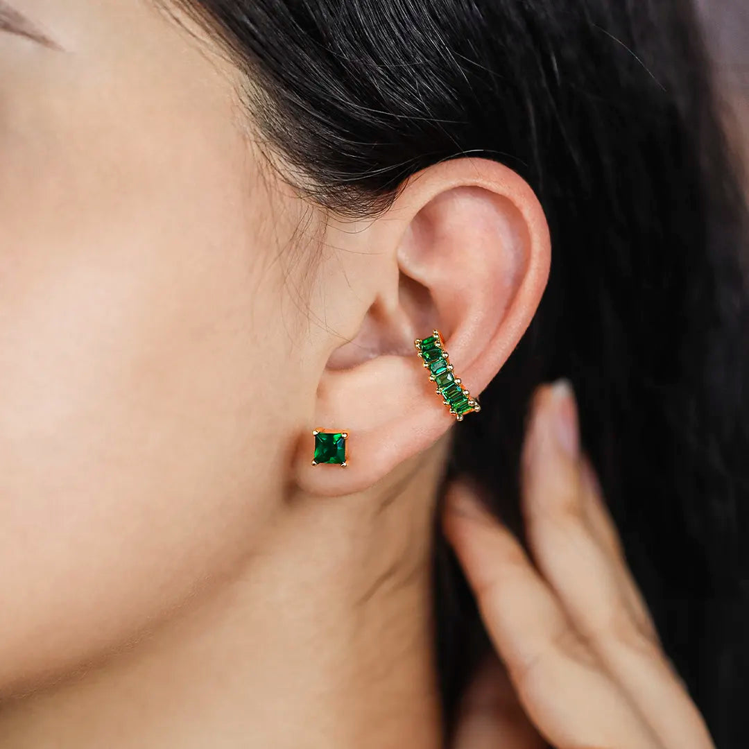 Oreja de mujer con earcuff en color amarillo de 18 quilates y cristales de color verde, hechos en Joyería Caracas. 