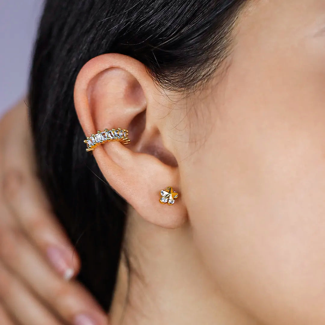 Oreja de mujer con earcuff en color amarillo de 18 quilates con cristales de color blanco, hecho en Joyería Caracas. 