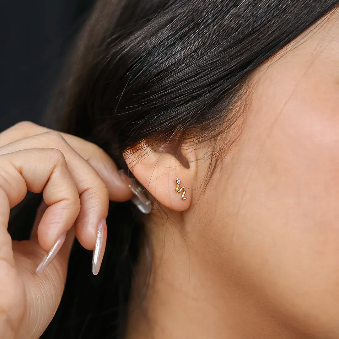 Oreja de mujer con topito en forma de serpiente en oro amarillo de 18 quilates con cristal de color blanco, hecho en joyeria caracas. 